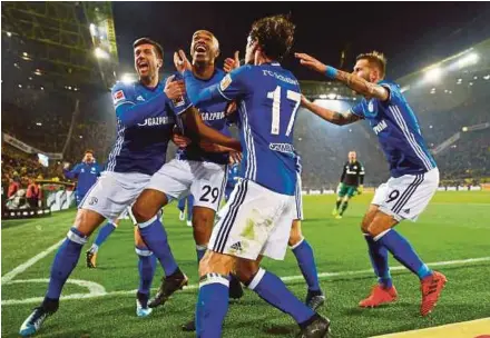  ?? REUTERS PIC ?? Schalke’s Naldo (second from left) celebrates with teammates after scoring the fourth goal in their Bundesliga match against Dortmund.