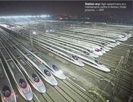  ?? — AFP ?? Station-ary: High-speed trains at a maintenanc­e centre in Wuhan, Hubei province.