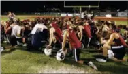  ?? JOE SKIPPER — THE ASSOCIATED PRESS ?? Members of the Marjory Stoneman Douglas High School football team pray together as they began practice for a new season just after midnight on Monday in Parkland, Fla.