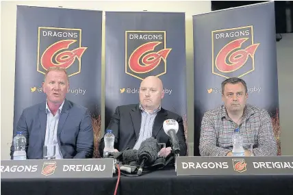  ??  ?? > Dragons chief executive Stuart Davies, left, with coach Bernard Jackman and Welsh Rugby Union chief executive Martyn Phillips, right, in front of the new Dragons logo yesterday PICTURE: Huw Evans Agency