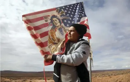  ??  ?? Brandon Nez displays his flag near his jewelry stand in Monument Valley, Utah, on 25 October 2018. Photograph: Rick Bowmer/AP