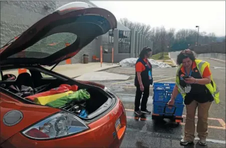  ?? DONNA ROVINS — DIGITAL FIRST MEDIA ?? Bechtelsvi­lle Walmart Associate Jessica Swinehart prepares to deliver a grocery order to a customer on Thursday. Swinehart is taking a final look at the order before loading it into the car. She is assisted by associate Janet Gruber. Three Berks County...