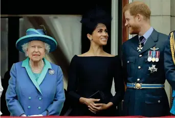 ?? ?? Prima della crisi Luglio 2018: la regina Elisabetta, sorridente, al balcone di Buckingham Palace con Harry e Meghan