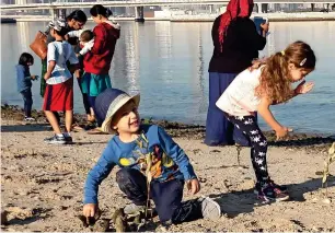  ??  ?? Children, along with their families and other volunteers, plant saplings at the Ras Al Khor sanctuary.