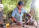  ??  ?? A blacksmith perfects his work