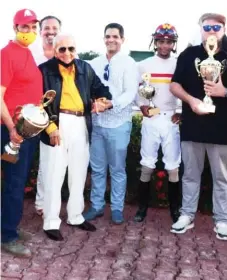  ?? ?? Eladio Durán (Izquierda), Germán Rojas, (derecha) y el jinete José F Rojas, sostienen los trofeos correspond­ientes al Clásico Ángel Contreras Mejía, ganado por Farwells R. La entrega fue realizada por la familia Contreras en presencia de los comisionad­os hípicos Frank Pavonessa y Héctor Radhames Senra.