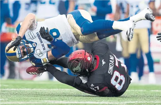  ?? TODD KOROL THE CANADIAN PRESS ?? Winnipeg Blue Bombers' Taylor Loffler tackles the Stampeders' Richard Sindani on Sunday in Calgary. The Stamps will face the Ottawa Redblacks on Nov. 25.