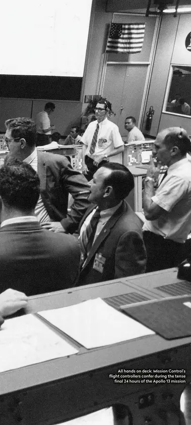  ??  ?? All hands on deck: Mission Control’s flight controller­s confer during the tense final 24 hours of the Apollo 13 mission