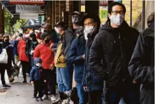  ?? Jessica Christian / The Chronicle ?? Customers line up to shop at an Oakland market. Coronaviru­s infections already have passed the peak of the summer surge.