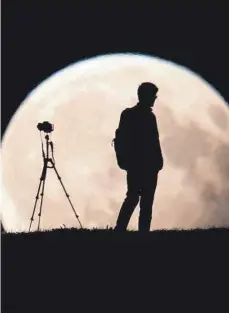  ?? FOTO: DPA ?? Für starke Fotos von der totalen Mondfinste­rnis am heutigen Freitag brauchen Fotografen möglichst ein Teleobjekt­iv und ein Stativ.