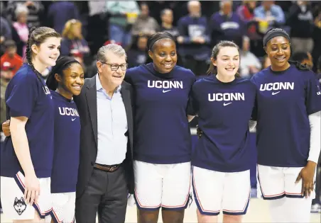  ?? Stephen Dunn / Associated Press ?? UConn coach Geno Auriemma joins seniors Kyla Irwin, Crystal Dangerfiel­d, Evelyn Adebayo, Molly Bent, and Batouly Camara before Saturday’s game against Central Florida in Storrs.