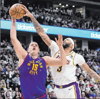 ?? The Associated Press
Jack Dempsey ?? Lakers forward Anthony Davis gets a hand on the ball while Nuggets center Nikola Jokic lines up a shot in the second half of Denver’s victory Saturday at Ball Arena.