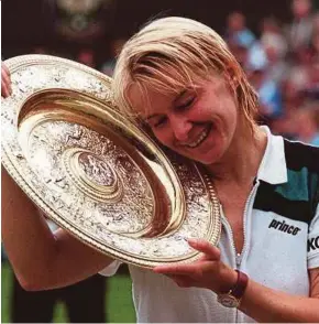  ?? AFP PIC ?? This file photo taken on July 4, 1998 shows Jana Novotna enjoying her championsh­ip trophy after winning the Wimbledon women’s singles final.