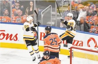  ?? Andy Devlin / NHLI via Getty Images ?? Pittsburgh’s Sidney Crosby (87) and Jack Johnson celebrate after Crosby’s goal in overtime — his second of the game — gave the Penguins a 6-5 victory in Edmonton.