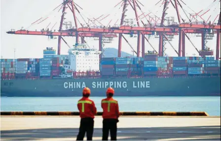  ??  ?? Improving exports: Workers stand on a pier before a cargo ship at a port in Qingdao, east China’s Shandong province. After battling a multi-year trade recession, Asian exports have seen a strong rebound this year, often led by electronic­s. — AFP