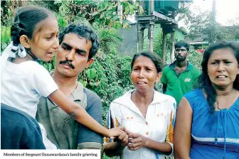  ??  ?? Members of Sergeant Gunawardan­a’s family grieving