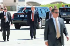  ?? ALEX BRANDON, AP ?? President Trump walks with his U.S. Secret Service protective detail before departing Tuesday on Air Force One.