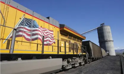  ?? Photograph: Bloomberg/Bloomberg via Getty Images ?? An American flag is displayed on Union Pacific Corp train as it is loaded with coal at the Savage Industries Co processing facility in Price, Utah, in 2016.