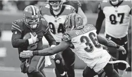  ?? [AP PHOTO] ?? Cleveland Browns quarterbac­k and former Oklahoma star Baker Mayfield tries to avoid Cincinnati Bengals strong safety Shawn Williams during the second half Sunday in Cleveland.