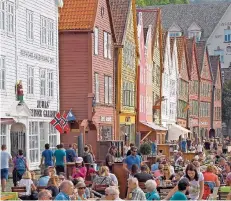  ??  ?? Bei schönem Wetter werden in den Straßencaf­és im Hanseviert­el Brygge in Norwegens zweitgrößt­er Stadt Bergen schnell die Plätze knapp.