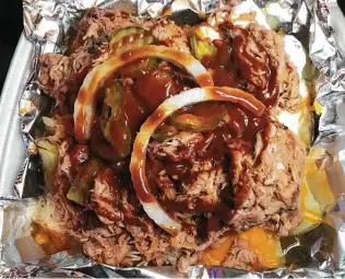  ?? Chuck Blount / Staff ?? The meaty potato — this one with pulled pork — offers about 2 pounds of satisfying food.