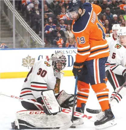  ??  ?? Blackhawks goalie Jeff Glass stones the Oilers’ Patrick Maroon during the second period Friday in Edmonton.