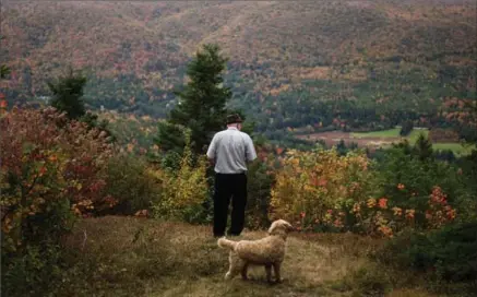  ?? IAN WILLMS, NEW YORK TIMES ?? Jim Austin stands on a lookout near the edge of his land in Cape Breton. His family offered three acres of land to anyone who would come and work at their business for five years. The offer went viral with people looking for work and a simpler way of...