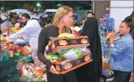  ?? Paul Hackett / REUTERS ?? Volunteers deliver food near the gutted Grenfell Tower, where the death toll had risen to 17 on Thursday.