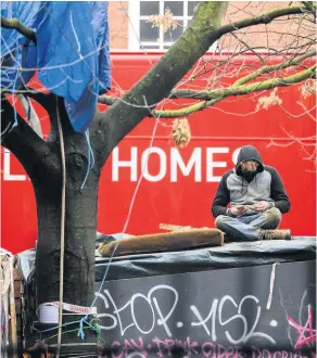  ??  ?? > An environmen­tal protestor remains in his position as bailiffs and police officers attempt to clear the site of a ‘Stop HS2’ camp. See Question 3