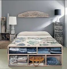  ??  ?? An organiser at the foot of a bed. Built-in cabinetry or a freestandi­ng
armoire can be alternativ­es to a closet in a small bedroom.