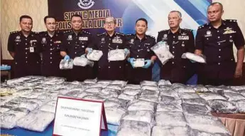 ??  ?? MAZLAN (tengah) bersama pegawainya menunjukka­n dadah jenis methapheta­mine seberat 96.7kg dengan nilai RM4.8 juta yang berjaya dirampas.
