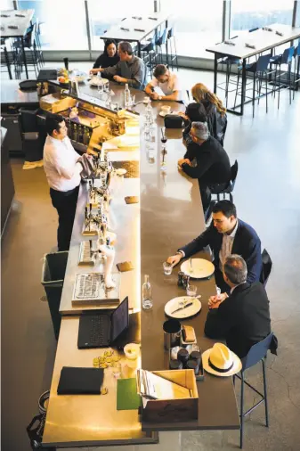  ?? Photos by Gabrielle Lurie / The Chronicle ?? Diners enjoy lunch at the bar in the mostly empty Corridor restaurant at 100 Van Ness Ave. Below, barista Andrew Worley makes coffee for a lunch patron at Corridor.