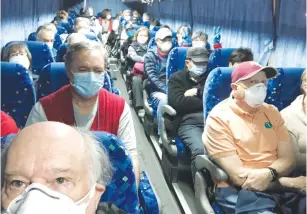  ?? (Courtesy of Philip and Gay Courter/via Reuters) ?? US PASSENGERS on board the ‘Diamond Princess’ cruise ship, who chose to leave, are transporte­d by shuttle bus from Yokohama to Haneda Airport to fly back to the United States yesterday.