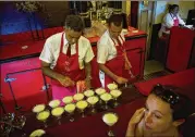  ?? RAMON ESPINOSA / ASSOCIATED PRESS ?? Bartenders prepare daiquiris with Cuban Havana Club rum at the Floridita bar in Havana on Friday.