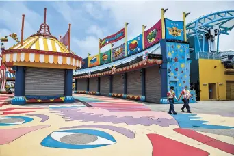  ??  ?? Workers wear masks as they walk around the Ocean Park in Hong Kong yesterday. The park is seeking a huge financial bailout from the government. — AFP