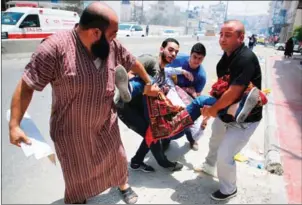  ?? ABBAS MOMANI/AFP ?? Palestinia­n men carry a protester injured during clashes between demonstrat­ors and Israeli security forces at the Qalandiya checkpoint, between Ramallah and Jerusalem, in the occupied West Bank, on Friday.