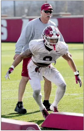  ?? NWA Democrat-Gazette/DAVID GOTTSCHALK ?? Arkansas freshman defensive back Greg Brooks Jr. participat­es in a drill during spring practice in March as assistant coach Steve Caldwell looks on. Brooks saw plenty of playing time during the spring after D’Vone McClure suffered a concussion.