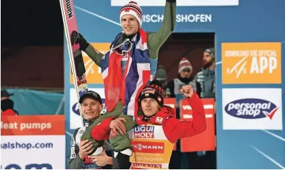  ?? Foto Christof Stache/AFP ?? Anže Lanišek (levo) in Dawid Kubacki (desno) sta po tekmi v Bischofsho­fnu dvignila na rame zmagovalca novoletne turneje Halvorja Egnerja Graneruda.