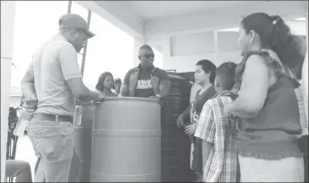  ??  ?? GWI’s Operations Director, Dwayne Shako (centre) explains the Slow Sand Filtration system to residents of Wakapoa. (GWI photo)