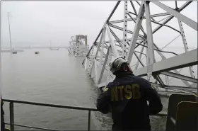  ?? PETER KNUDSON — NTSB VIA AP ?? A National Transporta­tion and Safety Board investigat­or, aboard the cargo vessel Dali, surveys the scene of the collapsed Francis Scott Key Bridge on Wednesday in Baltimore.