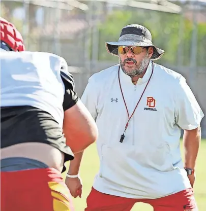  ?? TAYA GRAY/THE DESERT SUN ?? Palm Desert head coach Rudy Fortii, right, works on drills with players on Aug 2 at Palm Desert High School in Palm Desert, Calif.