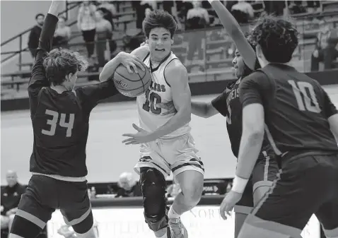  ?? Photos by Kin Man Hui/Staff photograph­er ?? Reagan’s Luke Price drives into the lane against Brandeis’ Andrew Byerly (34) and Trevor Short in Friday night’s clash of teams unbeaten in district play. Price scored a game-high 26 points in Reagan’s win, while teammate Aidan Richard added 25.