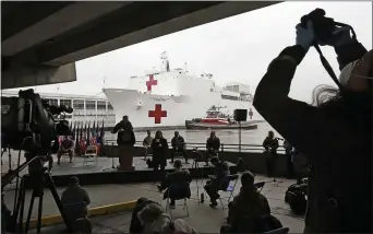  ?? KATHY WILLENS — THE ASSOCIATED PRESS ?? A journalist records speakers at a press briefing following the arrival of the USNS Comfort, a naval hospital ship with a 1,000bed-capacity, Monday at Pier 90in New York. The ship will be used to treat patients who do not have the new coronaviru­s as land-based hospitals fill up to capacity with those that do.