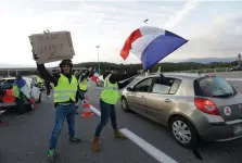  ??  ?? Chaos: Protesters with a sign reading ‘Free toll’ after they opened toll gates in Antibes, France. Photo: Claude Paris/AP