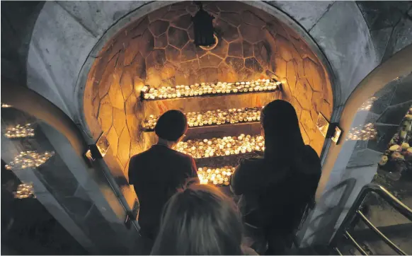  ?? EPA ?? Worshipper­s light candles at St Joseph’s Cathedral Catholic Church after Mass on Christmas Eve in Abu Dhabi