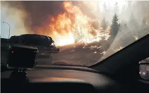  ?? ROBERT MURRAY ?? Dramatic images like this, taken from a car window as Fort McMurray residents fled the wildfire on June 3, are still fresh for evacuees.