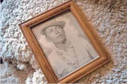  ??  ?? An earlier photo of Navajo Code Talker Joe Vandever Sr., on a sheepskin in his family’s hogan in Haystack, New Mexico.