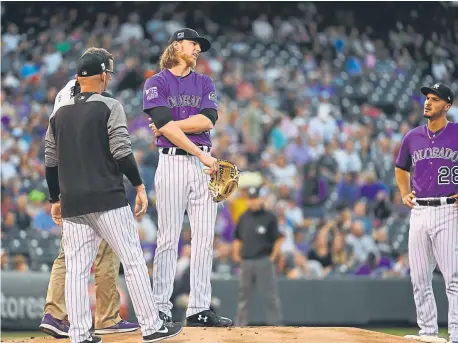  ?? Andy Cross, The Denver Post ?? Rockies starting pitcher Jon Gray grimaces as he grabs his side during the first inning Saturday night at Coors Field. Gray gave up five runs on seven hits in two innings. Chad Bettis came on in relief.