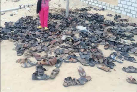  ?? THE ASSOCIATED PRESS ?? Shoes of victims remain outside Al-Rawda Mosque in Bir al-Abd in Egypt’s Sinai on Saturday, a day after attackers killed hundreds of worshipper­s. It was Egypt’s deadliest attack by Islamic extremists in the country’s modern history.