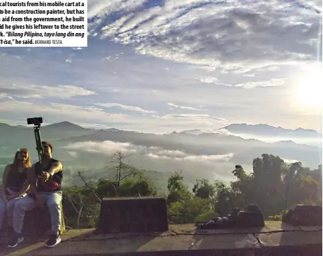  ?? BERNARD TESTA ?? WITH the majestic Sierra Madre as a backdrop, Jigger Figuro, 38, serves hot goto to local tourists from his mobile cart at a roadside view deck in Sitio Cabading, Barangay San Jose, Antipolo City. Figuro used to be a constructi­on painter, but has been out of work since the lockdowns in March. With the P6,500 he received in cash aid from the government, he built the cart and started selling goto to local tourists, making at least P600 a day. He said he gives his leftover to the street kids in his community in Sitio Paenaan, Barangay San Jose, gratitude for a day’s work. “Bilang Pilipino, tayo lang din ang pwede tumulong sa isa’t-isa para umangat ulit ang mga tao. Suportahan natin ang isa’t-isa,” he said.